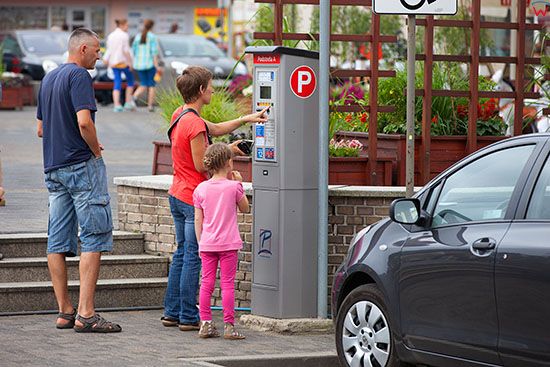 Wielun, kierowcy pobierajacy bilet parkingowy z parkomatu przy Placu Legionow. EU, PL, Lodzkie.