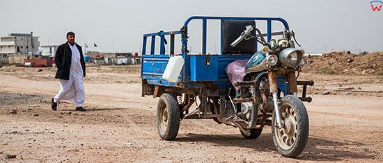 Irak,  Al-Hindiyah. Motocykl trojkolowy na gruntowej drodze.