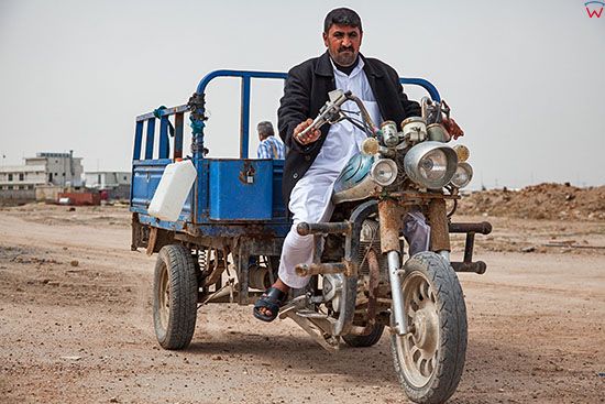 Irak,  Al-Hindiyah. Motocykl trojkolowy na gruntowej drodze.