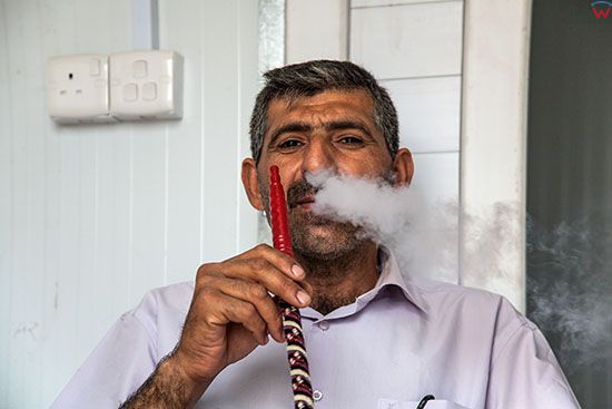 Irak, bliska okolica Karbali. Mezczyzna palacy fajke wodna - szisze.
