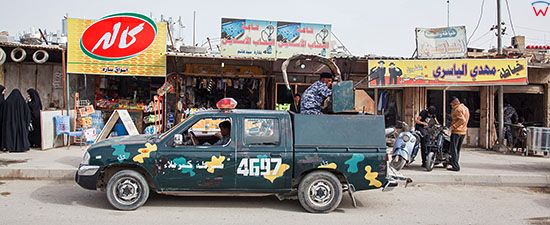 Irak, Karbala. Jeden z wielu policyjnych, opancerzonych samochodow z bronia automatyczna w centrum miasta.