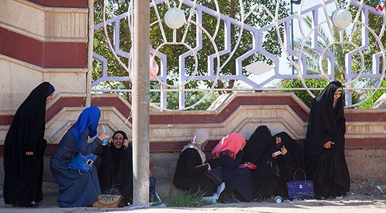 Irak, Karbala. Kobiety chroniace sie w cieniu w centrum miasta.