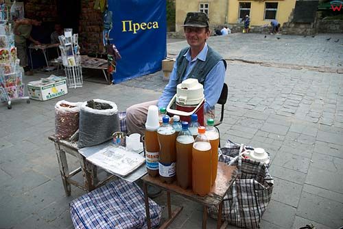 Lwów. Sprzedawca kwasu chlebowego przed pomnikiem Fedorowa.